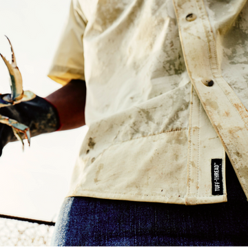 Close up of Tuff thread tag on a man wearing The Sawdust, while holding a crab