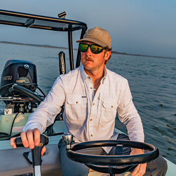 man driving boat wearing the skiff shirt