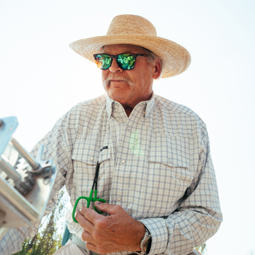 Man wearing The Soda Butte shirt and straw hat outdoors
