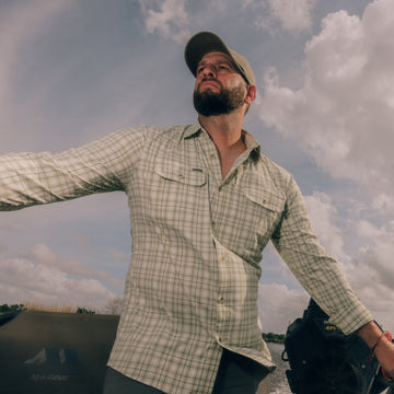 Man driving a boat while wearing The Swamp Boat shirt