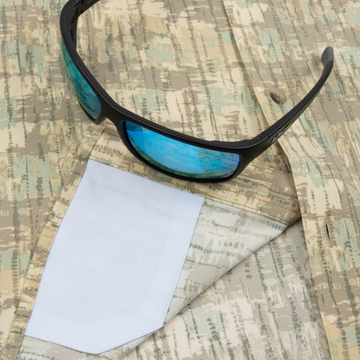 Closeup of sunglasses with lens cleaner on shirt