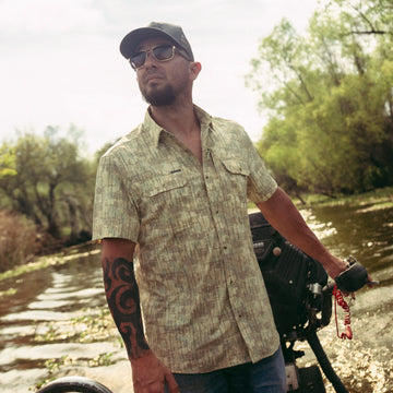 man driving boat wearing the swamp donkey shirt
