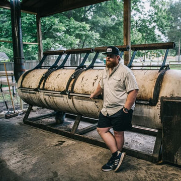 Man standing next to a smoker while wearing The Wildcatter