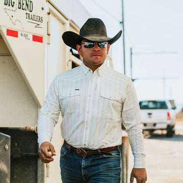 Man wearing The Crockett outdoor shirt with cowboy hat and sunglasses walking by trailer