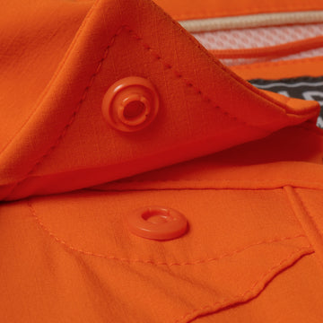 Close-up of orange fabric and snap button detail on The Dick Cheney shirt