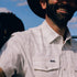 Man wearing The Whitefish outdoor shirt with a relaxed smile under a sunny sky