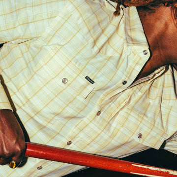 Close-up of a person wearing The Yellowbelly yellow plaid outdoor shirt with button details