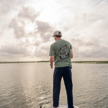 Man Fly fishing while wearing The Trout Rider T-Shirt