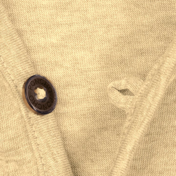 Close-up of warm sand colored knit fabric with dark button on The Baitcaster shirt