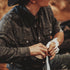 Man wearing The Pat Garrett patterned outdoor shirt and black hat wrapping his hands with white tape