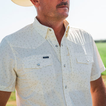 Man wearing The Medicine Bow patterned shirt and cowboy hat outdoors in sunlight