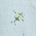 Close-up of light blue fabric with a small yellow and black ink stain or print detail